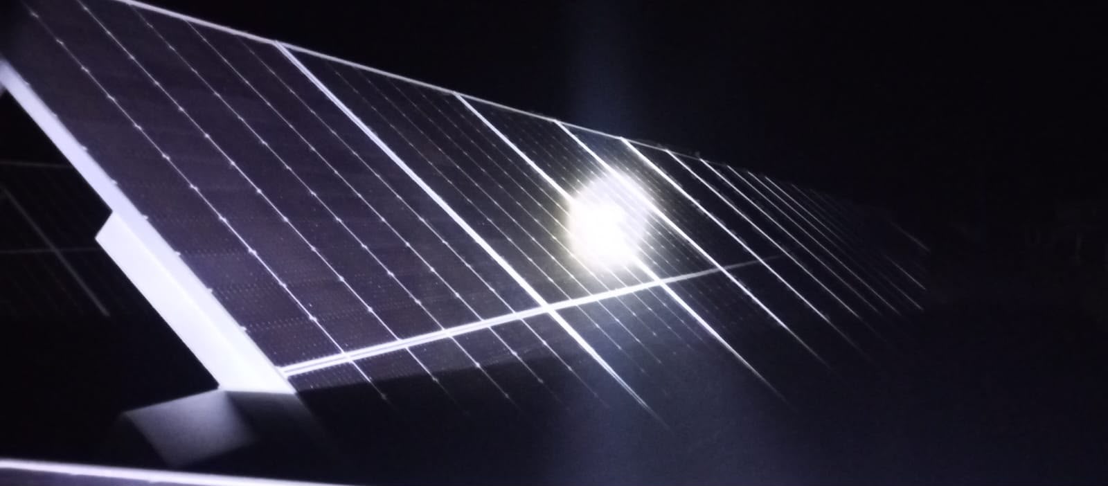 Inspección nocturna de un panel solar con linterna
